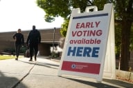 A sign that says Early voting available here stands on a sidewalk