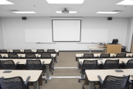 An empty college classroom, with a blank whiteboard at the front.