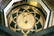 A worker crosses the world map embedded in the floor of the rotunda area inside Founders Hall on the campus of Soka University of America.