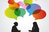 An illustration of two women, in silhouette, talking, with multicolored speech bubbles above their heads.