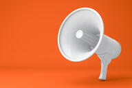 A 3-D rendering of a white megaphone against an orange background.