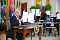 President Donald Trump holds up a signed executive order to dismantle the Department of Education. 
