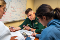 Three students work together at a table at the Academic Success Center at the University of South Florida