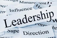 A collection of printed words, as if cut out from newspapers, including "leadership," direction," "influence," and "management,."