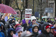 Protesters hold signs imploring Harvard University to resist the demands of President Trump's administration.