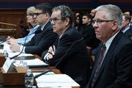 A photo of four people seated at a table in a hearing room in the U.S. Capitol