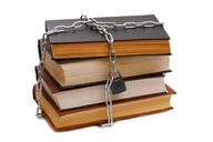 A stack of old library books that are chained and padlocked together. 