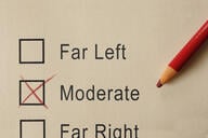 A pencil lies atop a paper survey. There are three boxes—for "far left," "moderate," and "far right"—and the middle box, for "moderate," has been marked with an "X."