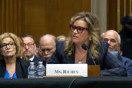 Kimberly Richey, a white woman with blond streaks in her hair, sits at a table in front of an audience during a confirmation hearing on Thursday.