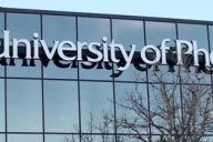 The University of Phoenix name and logo on the side of a glass building.