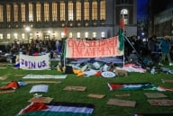 A night scene of the lawn at Columbia, covered in signs and Palestinian flags.