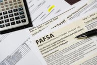 Close-up of federal financial aid application with calculator and tuition statement