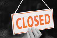 An orange and white sign that says "closed."