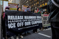 A photo of demonstrators with a large banner saying "Release Mahmoud Khalil Hands Off Our Students ICE Off Our Campuses Shut It Down for Palestine."