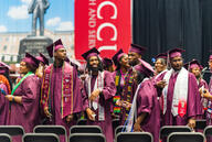 Students in maroon caps and gowns celebrate graduation at NCCU