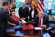 White House staff secretary Will Scharf hands U.S. President Donald Trump an executive order to sign in the Oval Office.