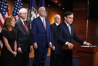 U.S. Speaker of the House Mike Johnson flanked by other congressional Republicans speaks at a podium.