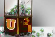 Illustration: A toy machine filled with "$" has been broken and some of the toys have fallen out of the damaged glass.