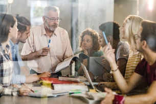 A professor meets with students over research.