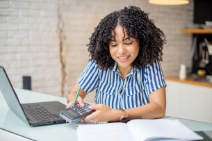 A female student uses a calculator to complete tax forms.