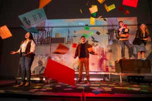 Four student actors in the musical "Ordinary Days" stand in a rain of colorful papers.