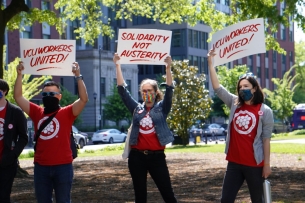 Three protesters stand outside, two holding up signs saying "VCU Workers United!" and one holding up a sign saying "Solidarity Not Austerity."