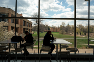 Community members eat at tables overlooking the College of Lake County Campus.