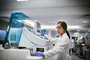 A young female researcher conducts a biomedical experiment in a laboratory.