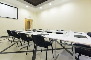 Empty classroom with black chairs around a white table