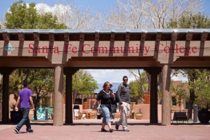 Two people walk under a columned passageway that says Santa Fe Community College