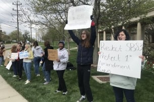 Students holding signs in opposition to Ohio Senate Bill 83