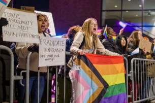 Protesters at the University of Buffalo, including one holding up a pride flag, demonstrate outside of a Michael Knowles appearance on campus.