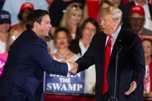 A photo of Ron DeSantis and Donald Trump shaking hands in 2018