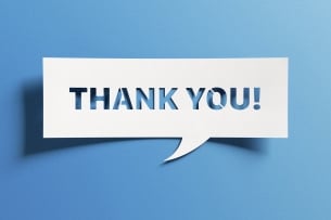 White text bubble–style sign on a blue background says, "Thank you!"