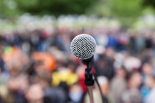 Microphone in focus in front of a blurred crowd of people