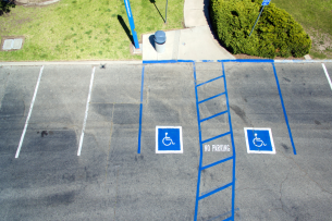 A parking lot has two designated spots for individuals with disabilities.