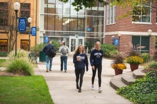Students in Penn State sweatshirts walk on the Penn State Shenango campus.
