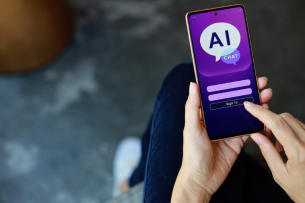 A close-up of a person's hands holding a smartphone displaying the purple log-in page for an AI chat bot.