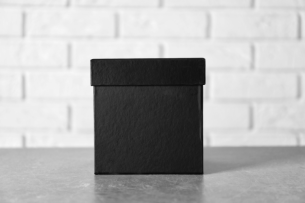 A black box on a table against the background of a white wall.