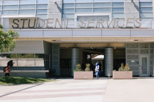 Student walks in front of student services center at East Los Angeles College