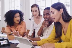 Diverse group of four students sitting together and working on a computer 