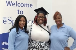 Three Black women, one of them wearing a graduation cap