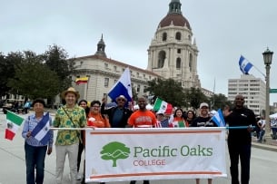 Pacific Oaks faculty, staff and students hold a banner during the Latino Heritage Parade and Festival in Pasadena. 