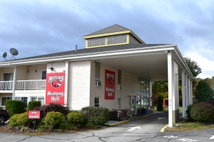 A hotel with red banners and signs that say "Mustang Hall"