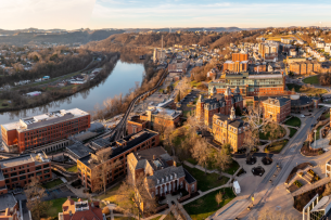 Aerial panoramic drone shot of the downtown campus of WVU in Morgantown, West Virginia, showing the river in the distance