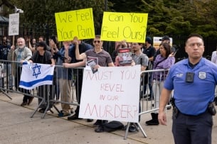 Students at a Brooklyn College counterprotest hold signs in support of Israel that say "We feel your pain," "can you feel ours?" and "must you revel in our murder?" One student has an Israeli flag