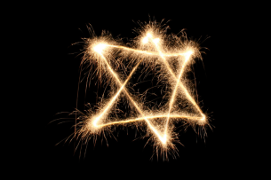 A sparkler in the shape of a Star of David, against a black background.