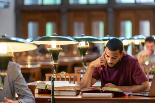 A Black student studies in a library