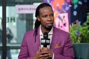 Ibram X. Kendi, a brown-skinned manw ith his dark hair pulled back in braids, wearing a purple suit jacket, is the founder and director of the Center for Antiracist Research. 