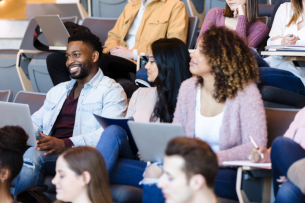 A racially diverse group of college students attends a lecture.